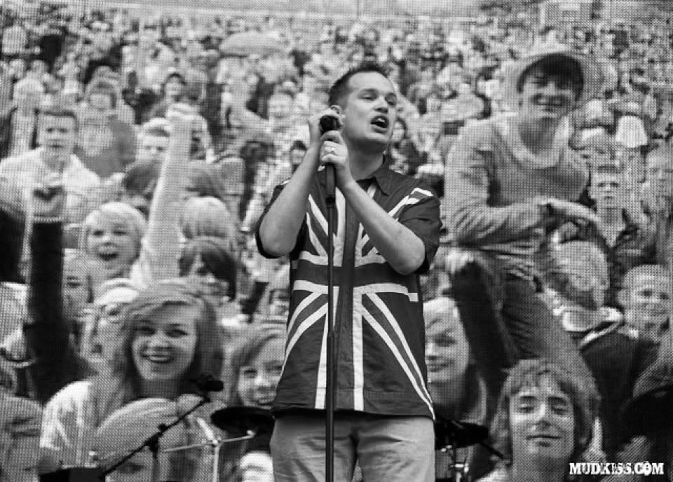 Phil Gwilliam performing at a microphone in front of an audience montage